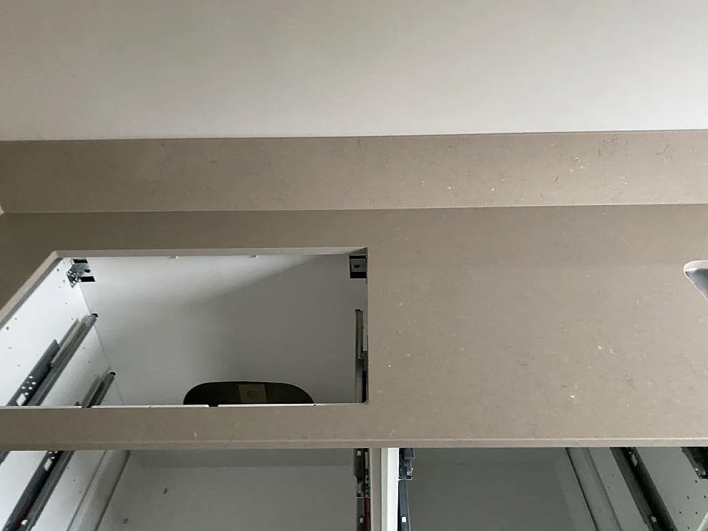 Bänkskiva i Silestone Coral Clay med urtag för häll, sett ovanifrån i ett kök under montering i Limhamn.
