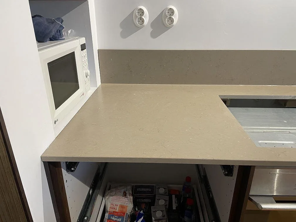 Köksbänkskiva i Silestone Coral Clay, matt Mocka-yta, med urtag för häll vid inbyggd ugn och stänkskydd i Limhamn.