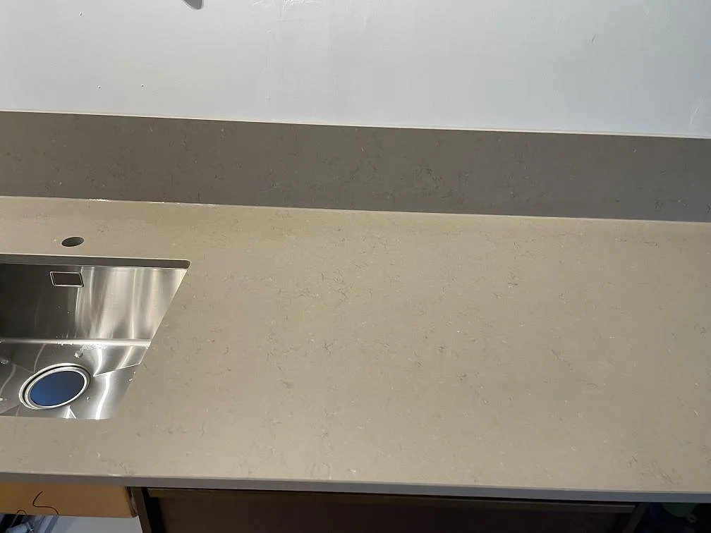 Detalj av Silestone Coral Clay bänkskiva, matt Mocka, med underlimmad rostfri diskho och matchande stänkskydd i Limhamn.