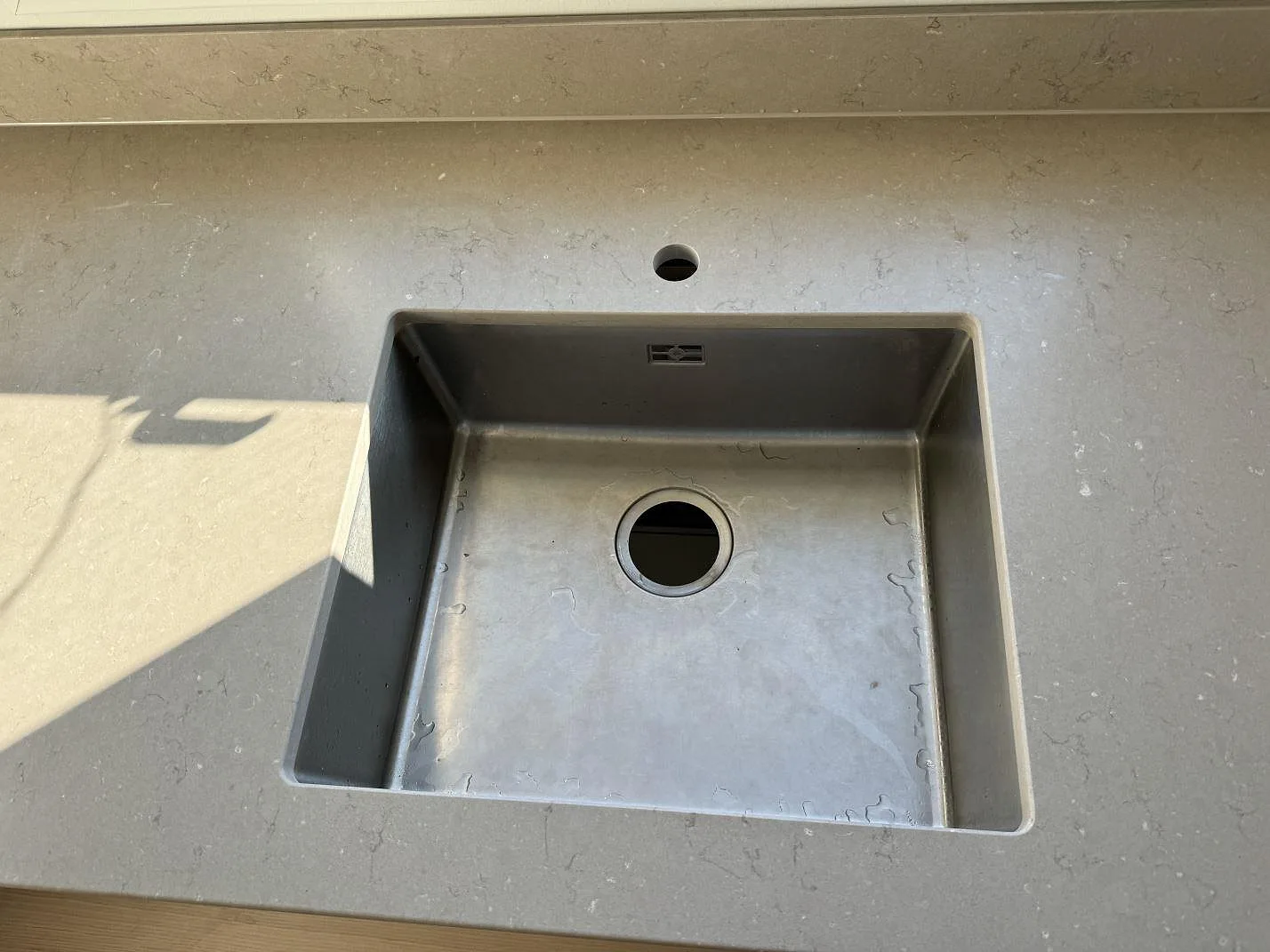 Detalj av Silestone Coral Clay, matt Mocka, runt diskho och kranhål i en köksbänkskiva i Limhamn.