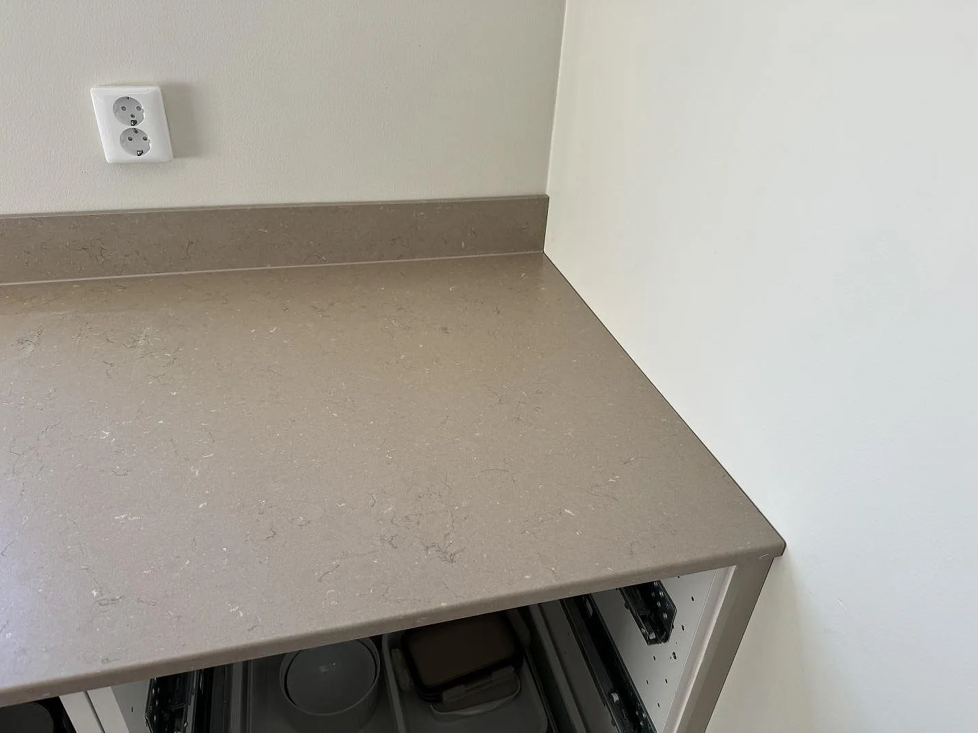 Sidovy av Silestone Coral Clay bänkskiva, matt Mocka, över öppna köksstommar med låg stänkkant i Limhamn.