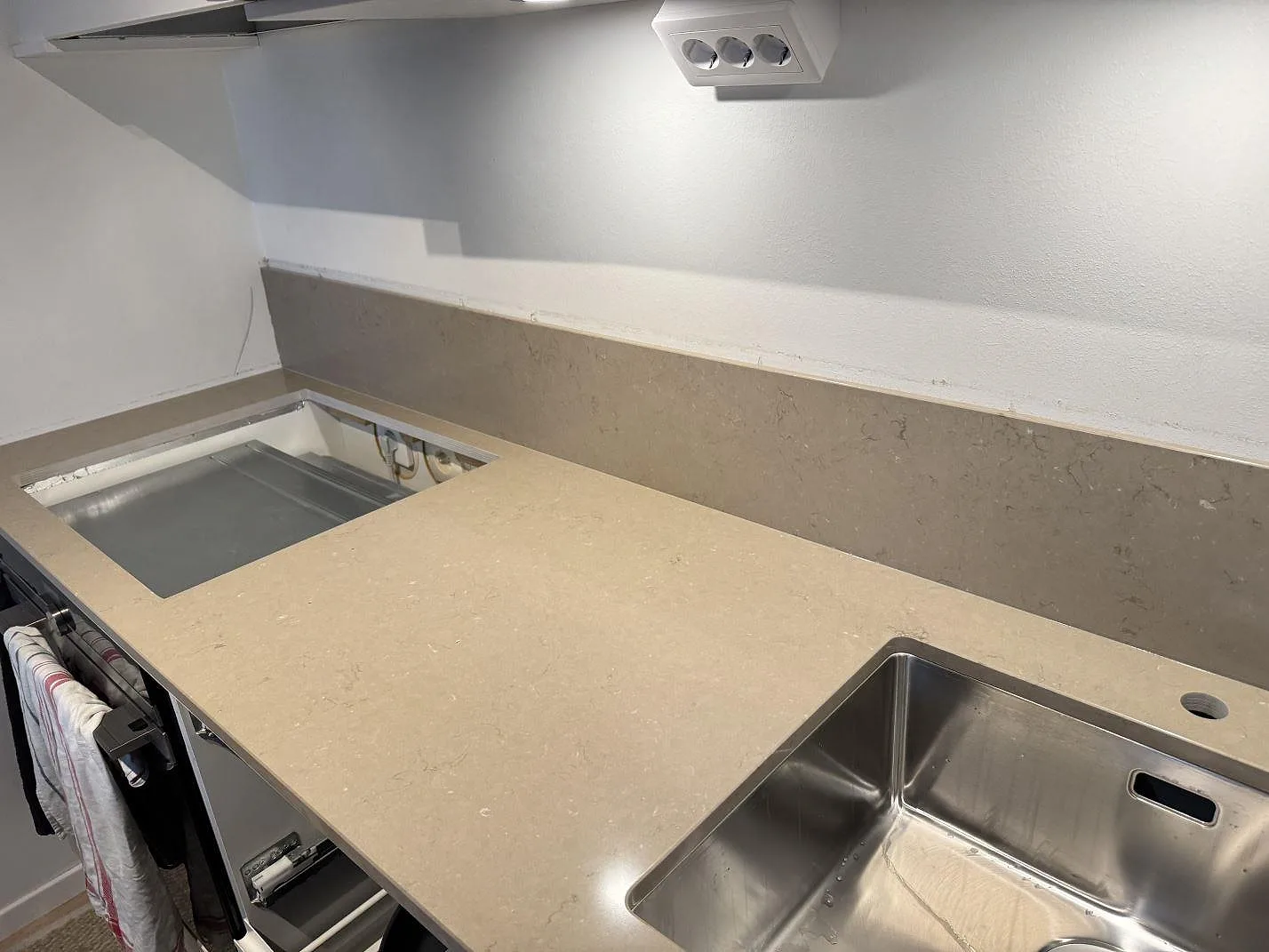 Polerad kompositbänkskiva i Silestone Coral Clay med hällöppning, stänkskydd och rostfri diskho i Limhamn.