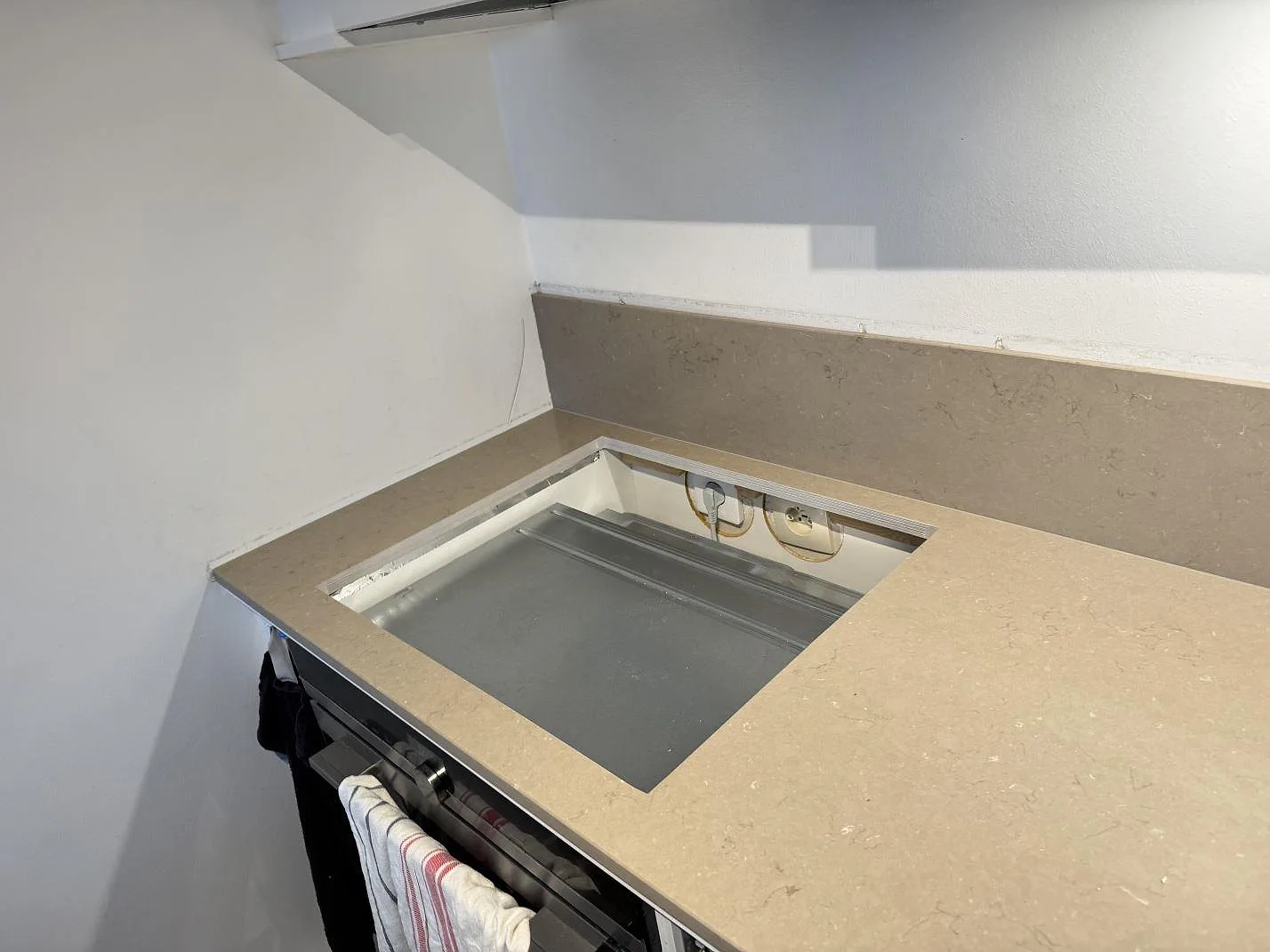 Hällöppning i polerad Silestone Coral Clay med 12 mm stänkskydd bakom bänkskivan i Limhamn.