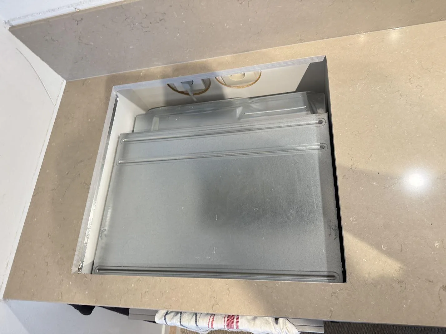 Närbild av hällöppning i polerad Silestone Coral Clay, monterad köksbänkskiva i Limhamn.