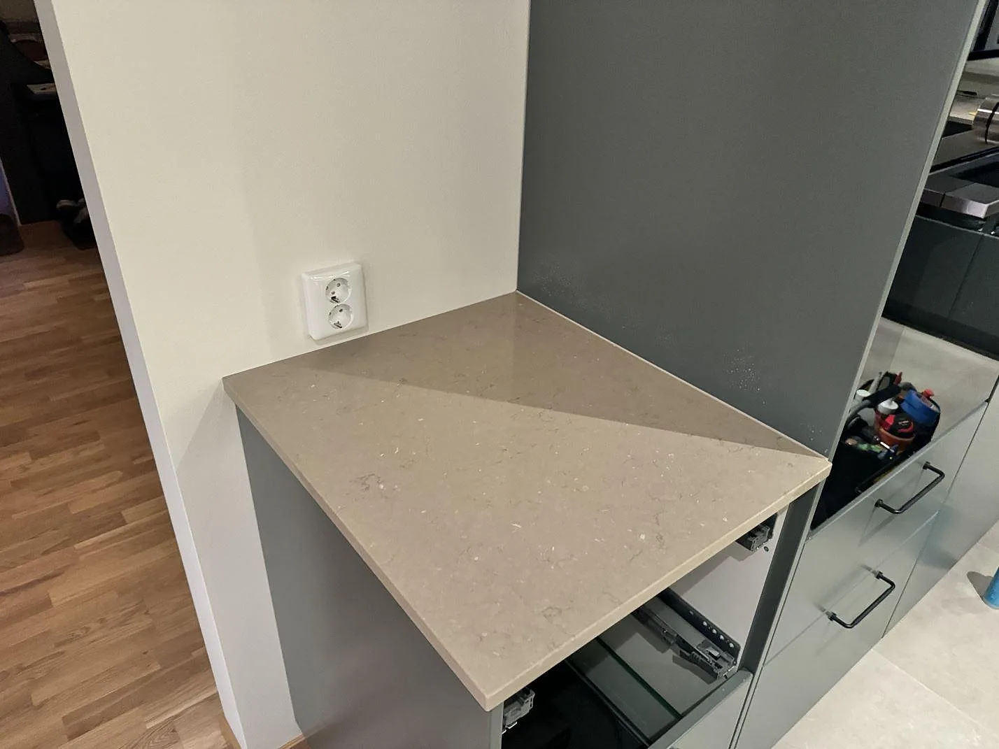 Sidovy av installerad köksbänkskiva i polerad Silestone Coral Clay över öppna stommar i ett kök i Löddeköpinge.