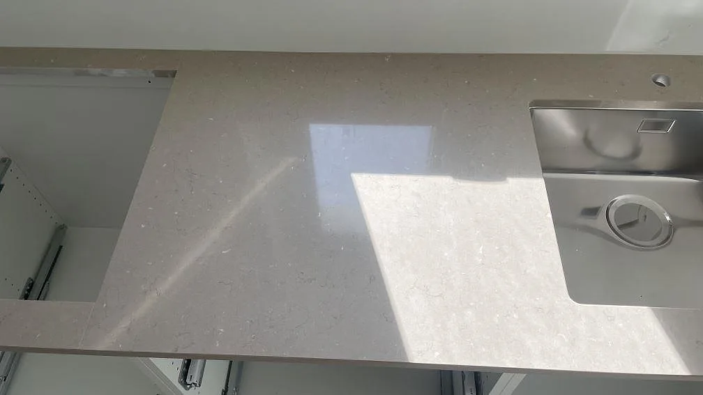 Polerad Silestone Coral Clay köksbänkskiva i Lomma med arbetsyta mellan förberett hälluttag och underlimmad rostfri diskho.