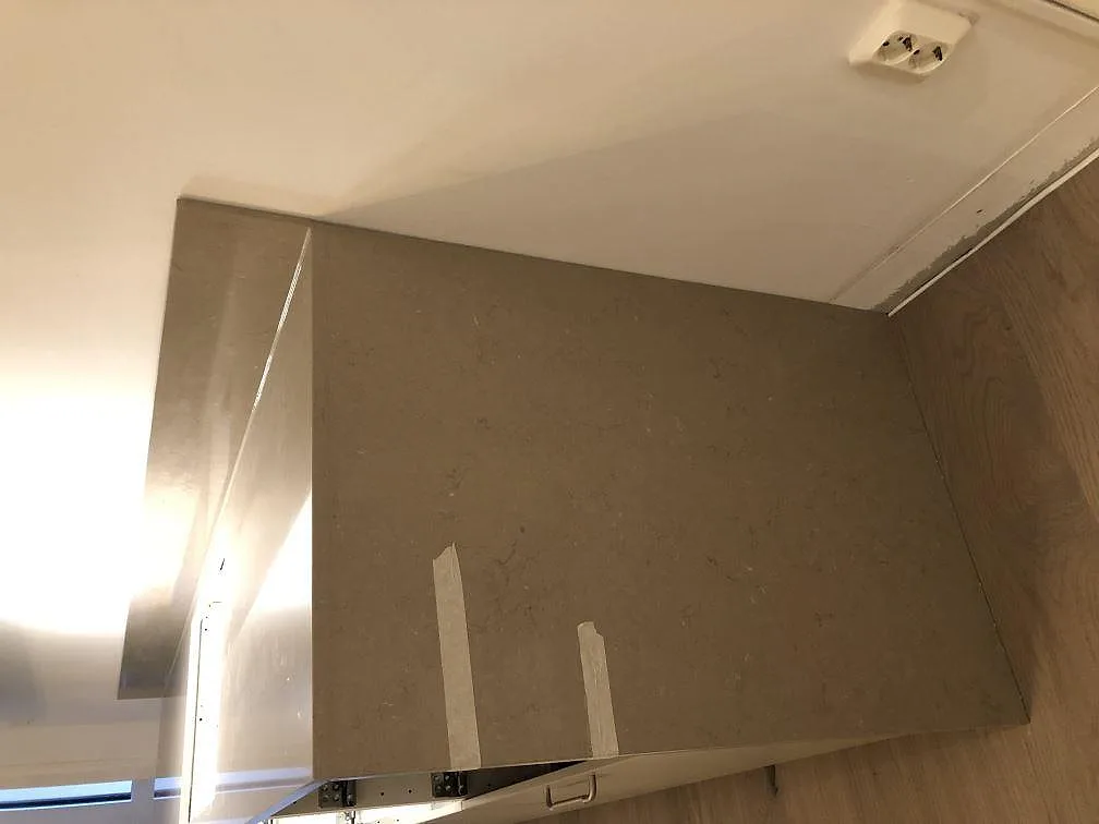 Närbild på Silestone Coral Clay köksbänkskiva med uppvikt stänkkant och synlig taupe ådring i ett kök i Malmö.