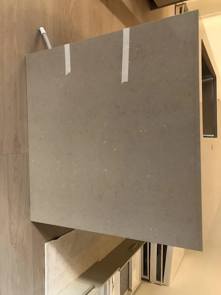 Detalj av köksö i Silestone Coral Clay med rostfri diskho och stenklädd sida i ett kök i Malmö.