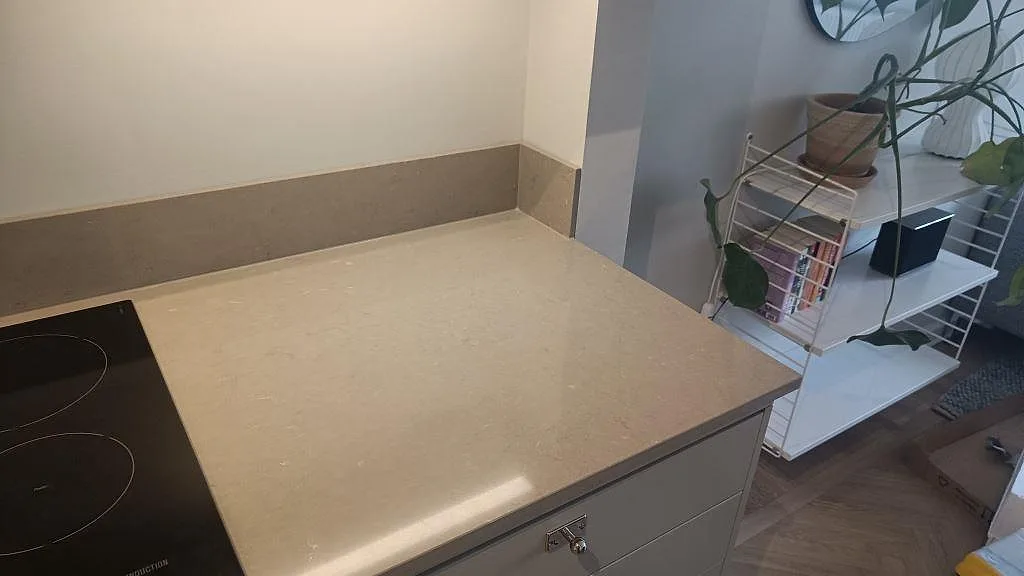Närbild på underlimmad rostfri diskho med korgsil i en taupefärgad Silestone Coral Clay bänkskiva och stänkkant i samma sten, Malmö.