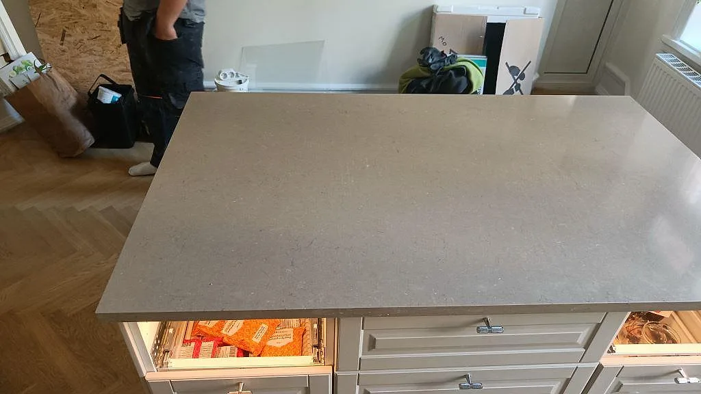 Köksö i matt Silestone Coral Clay sedd ovanifrån under montering i ett kök i Malmö.