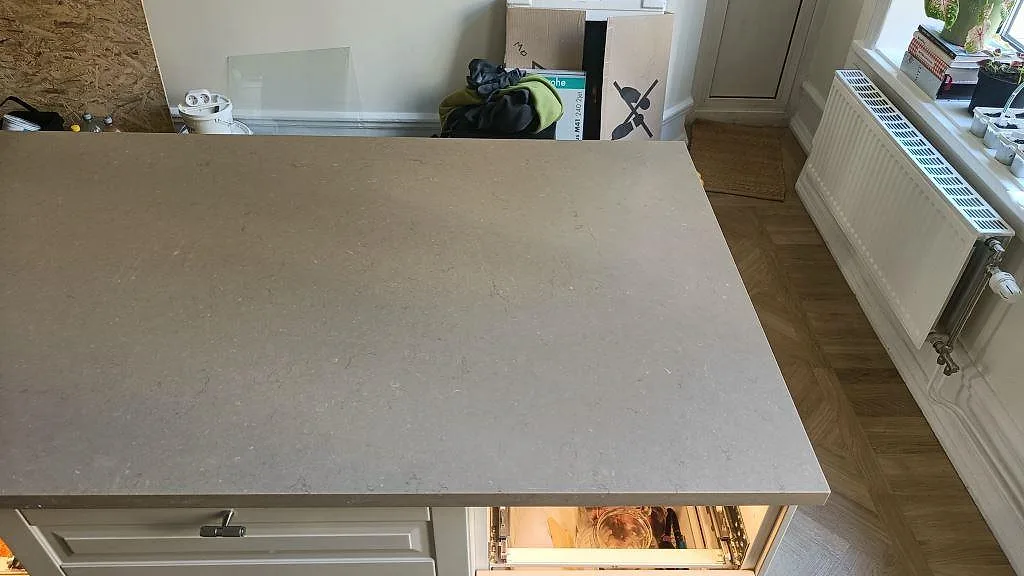Bänkskiva i Silestone Coral Clay i ett kök med fiskbensparkett och fönster i Malmö.