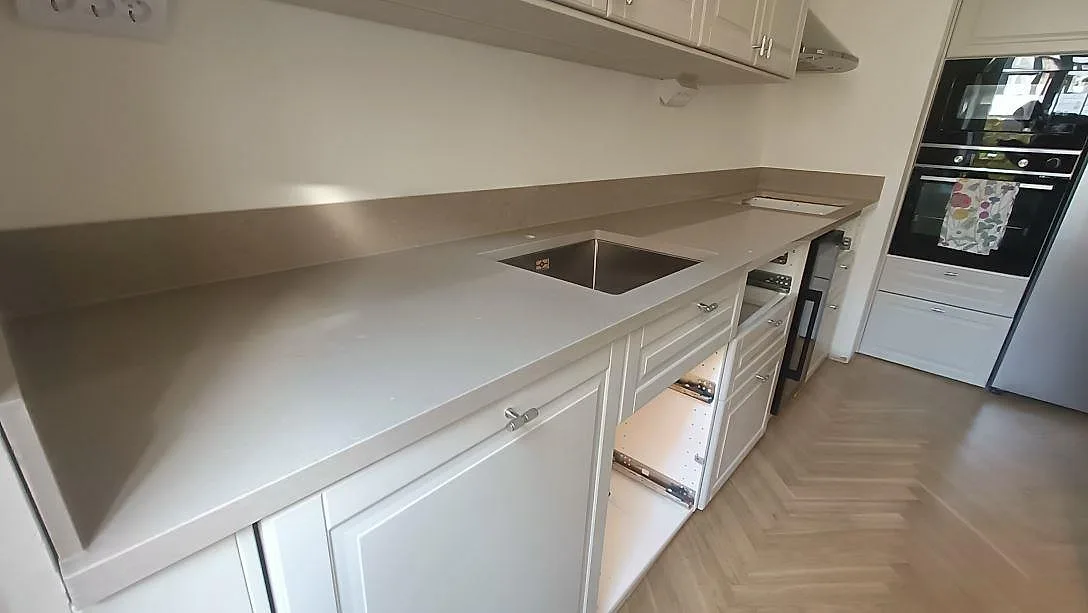 Bänkskiva i Silestone Coral Clay med underlimmad rostfri diskho och uppvikt stänkkant längs väggen i ett kök i Malmö, fotat under montering.