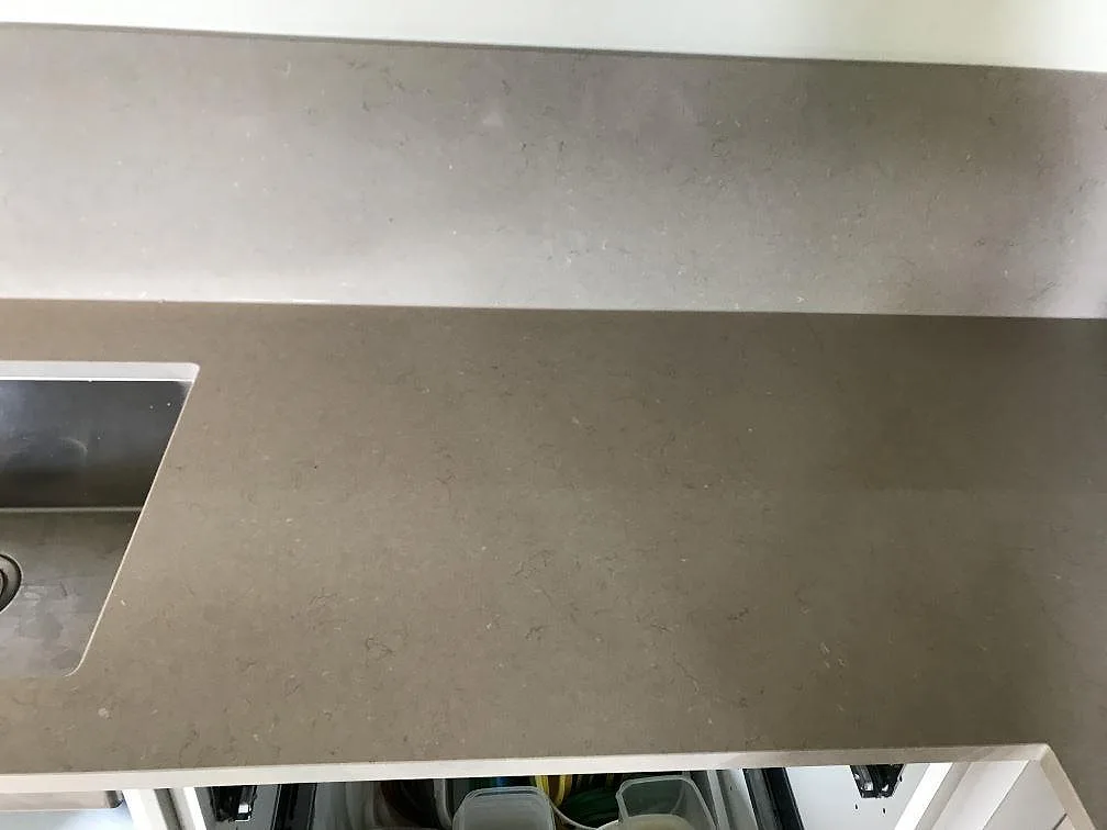 Underlimmad rostfri diskho infälld i en köksbänkskiva av matt Silestone Coral Clay i ett kök i Malmö.