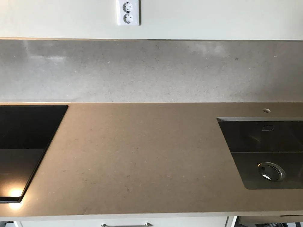 Köksbänkskiva i Silestone Coral Clay med induktionshäll och underlimmad rostfri diskho i matt komposit i ett kök i Malmö.