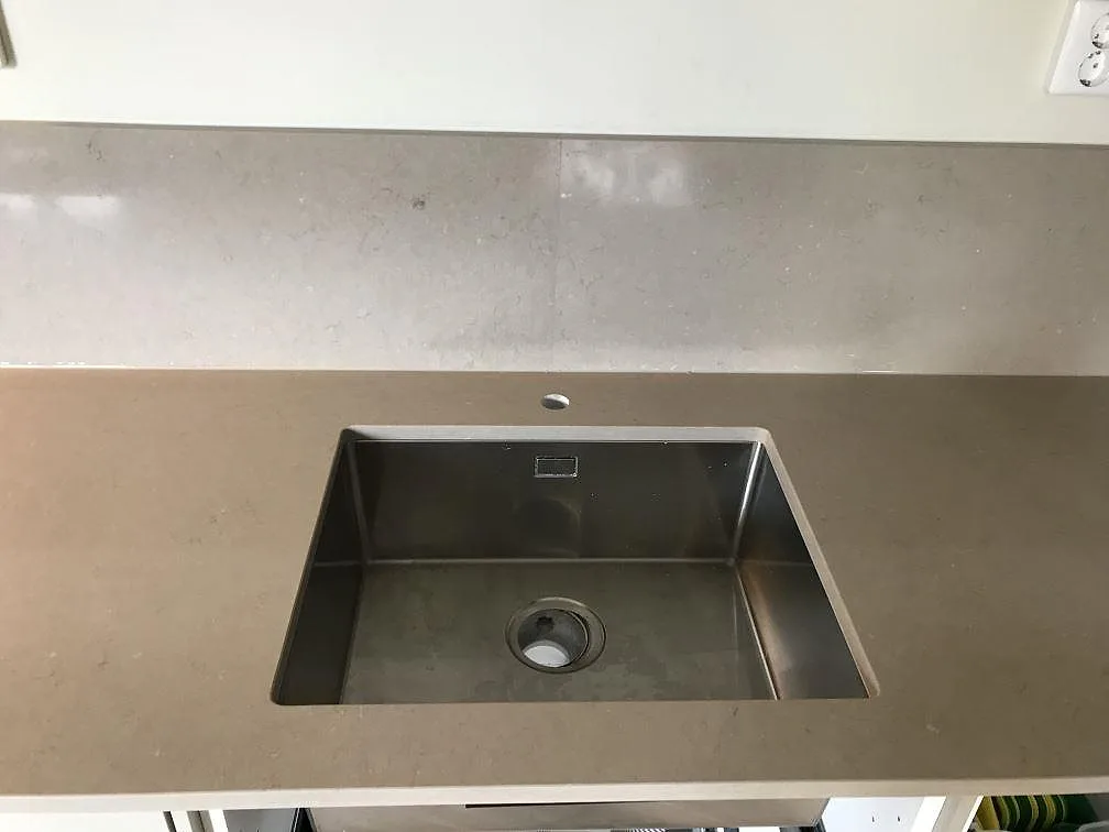 Underlimmad rostfri diskho i en köksbänkskiva av Silestone Coral Clay i matt finish i ett kök i Malmö.