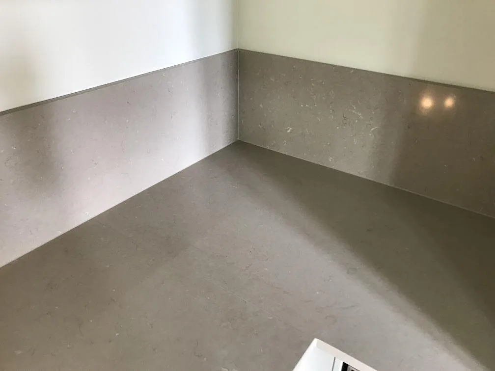 Uppvikt stänkkant i Silestone Coral Clay i hörnet av en köksbänk i Malmö, matt kvartskomposit.