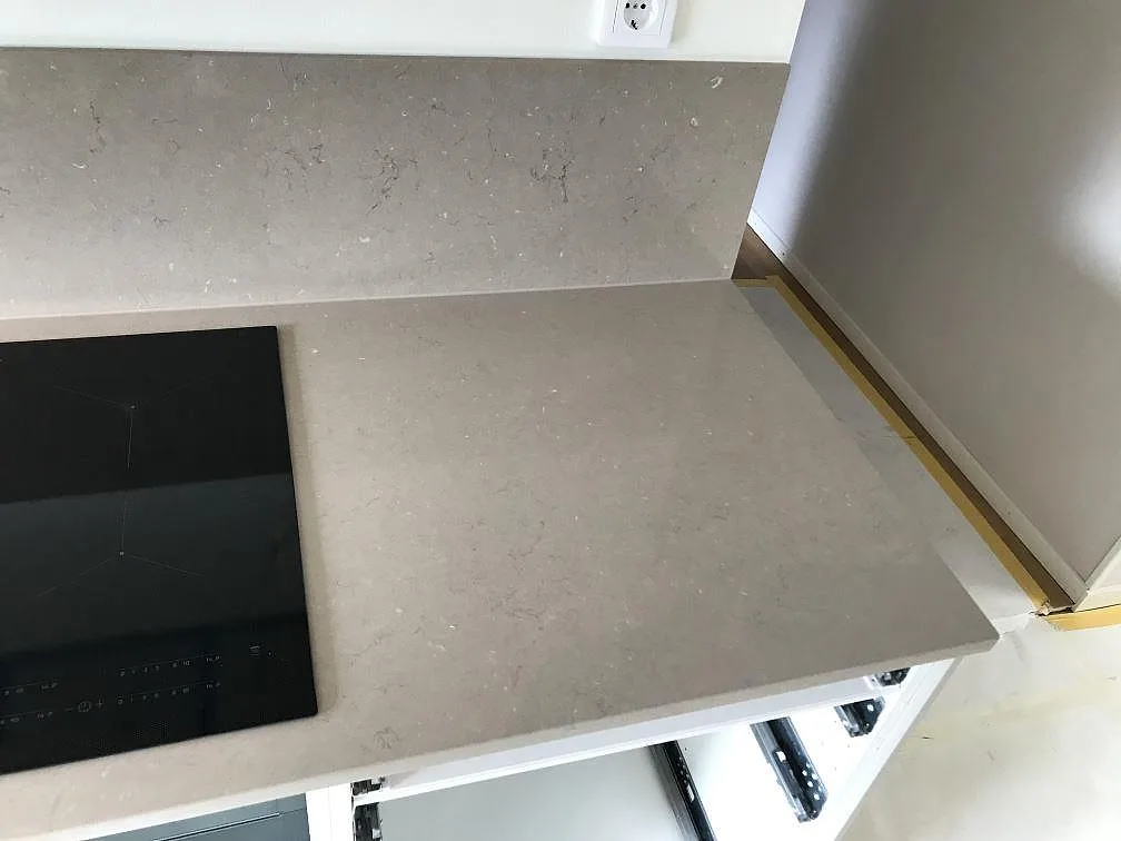 Hörn med två stänkväggar i Silestone Coral Clay som möter köksbänkskivan i samma taupe kvartskomposit i ett kök i Malmö.