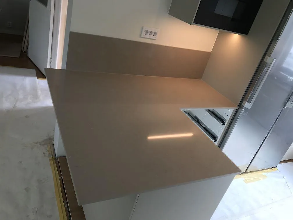 Närbild på underlimmad rostfri diskho med dubbla hoar i en köksbänkskiva i Silestone Coral Clay med stänkvägg i samma sten i Malmö.