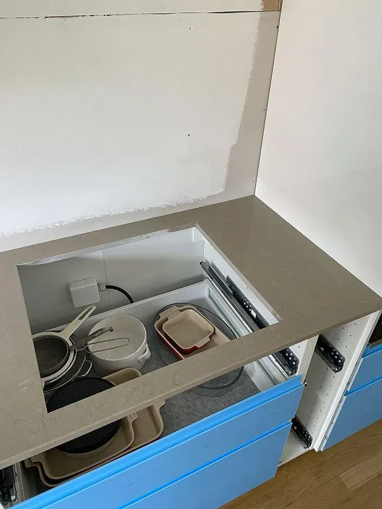 Installerad köksbänkskiva i polerad Silestone Coral Clay med stänkkant och skyddsfilmade skåp under montering i Malmö.