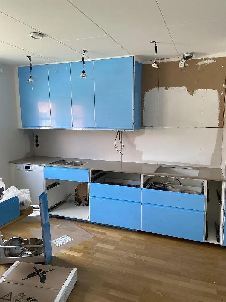 Frontvy av monterad Silestone Coral Clay-bänkskiva på vit köksstomme i ett kök i Malmö.