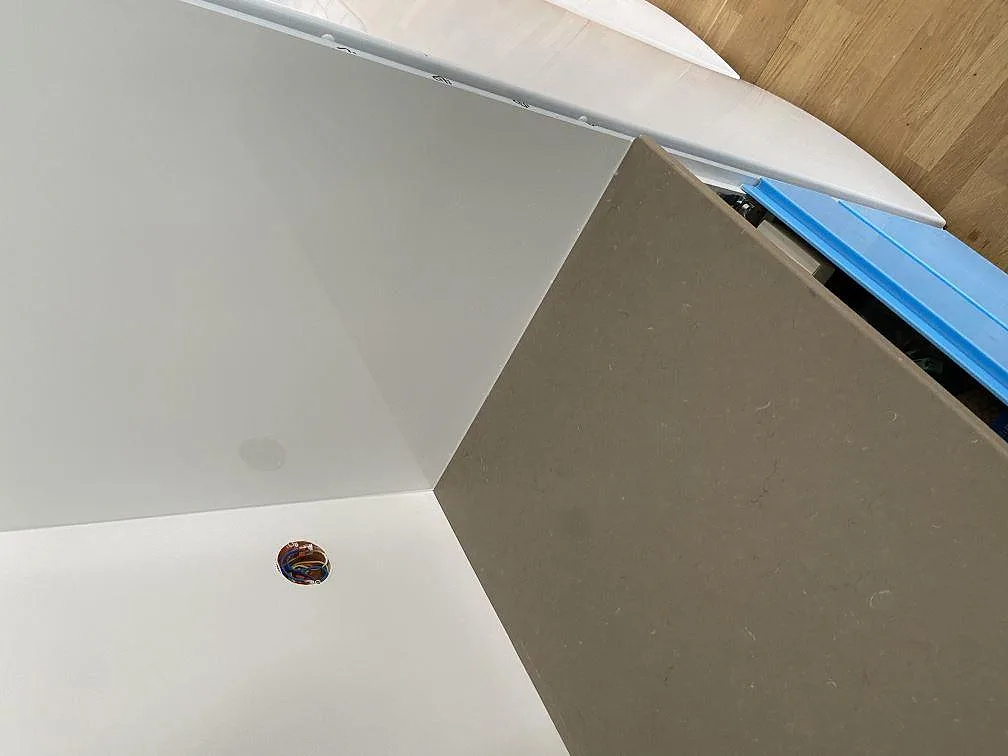 Kök under montering i Malmö med Silestone Coral Clay-bänkskiva, vita skåp med blå skyddsfilm och ekparkett.