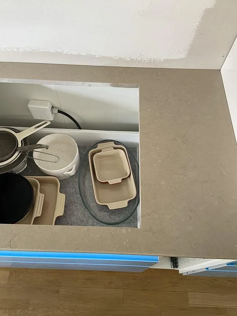 Polerad Silestone Coral Clay-bänkskiva med uppvikt stänkkant monterad längs väggen i ett kök under montering i Malmö.