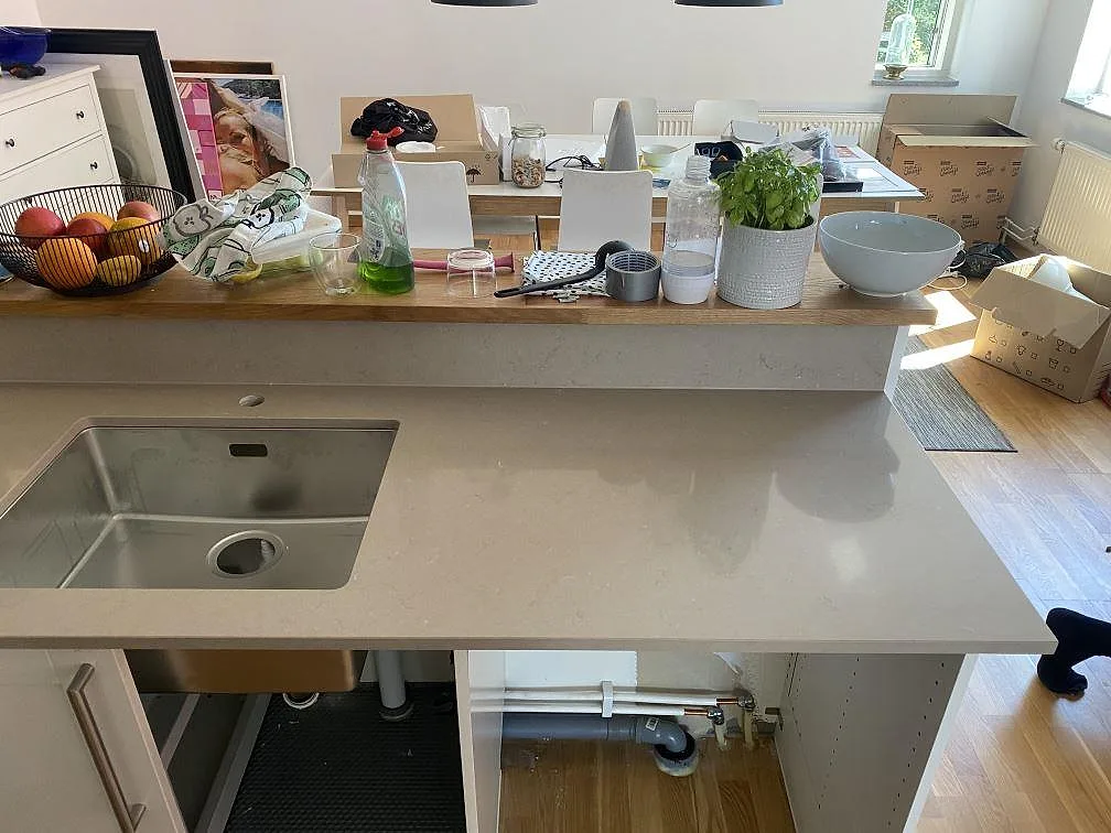 Köksbänkskiva i beige Silestone Coral Clay, polerad, med undermonterad rostfri diskho på en köksö i ett kök i Malmö.