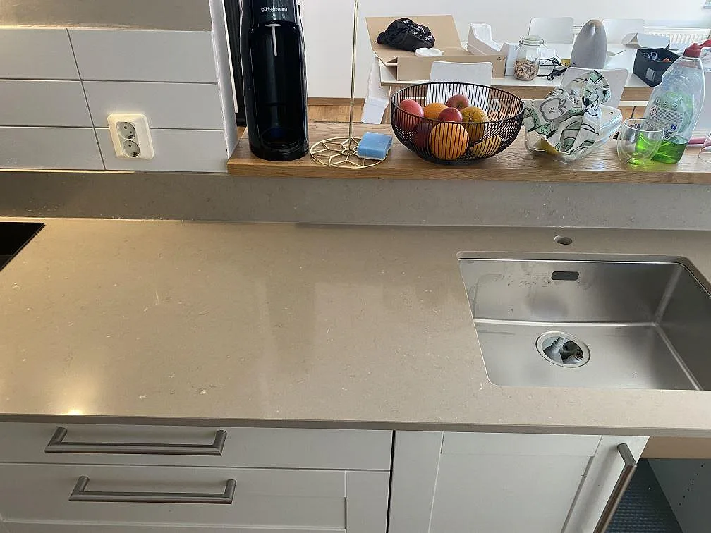 Polerad bänkskiva i Silestone Coral Clay med undermonterad rostfri diskho och induktionshäll längs köksbänken i Malmö.