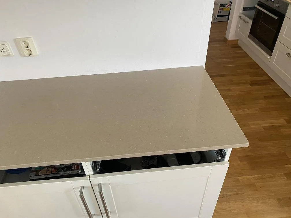 Köksö i Silestone Coral Clay, beige kvartskomposit med polerad yta, mot ekgolv i ett kök i Malmö.