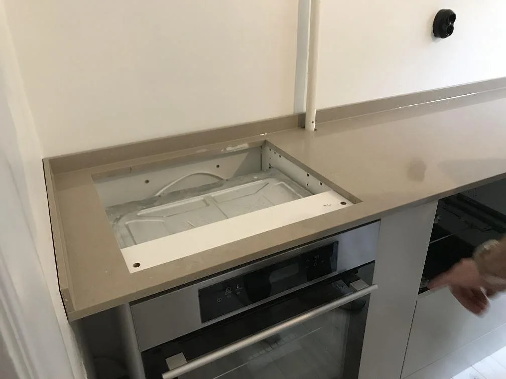Köksbänkskiva i Silestone Coral Clay med urtag för häll ovanför inbyggd ugn i ett kök i Malmö, polerad yta.