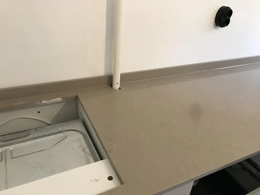 Bänkskiva i Silestone Coral Clay med hällurtag och stänkkant i ett kök i Malmö, varm gråbeige polerad sten.