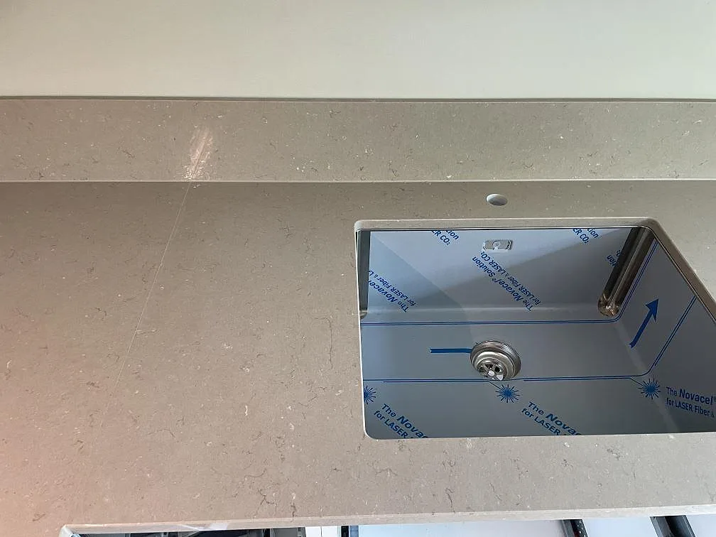Närbild på polerad Silestone Coral Clay bänkskiva med rostfri diskho och uppvikt stänkkant i Malmö.