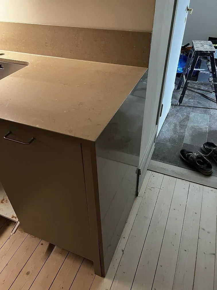 Sidovy av polerad Silestone Coral Clay bänkskiva på halvö, med synlig stenkant och monteringsmiljö i Malmö.