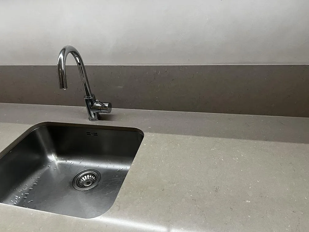 Detalj av underlimmad rostfri diskho och hög svängd blandare i en köksbänkskiva av Silestone Coral Clay i Malmö.