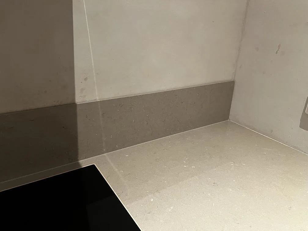 Hörnparti av köksbänkskiva i Silestone Coral Clay med matchande stänkskydd och infälld häll i Malmö.