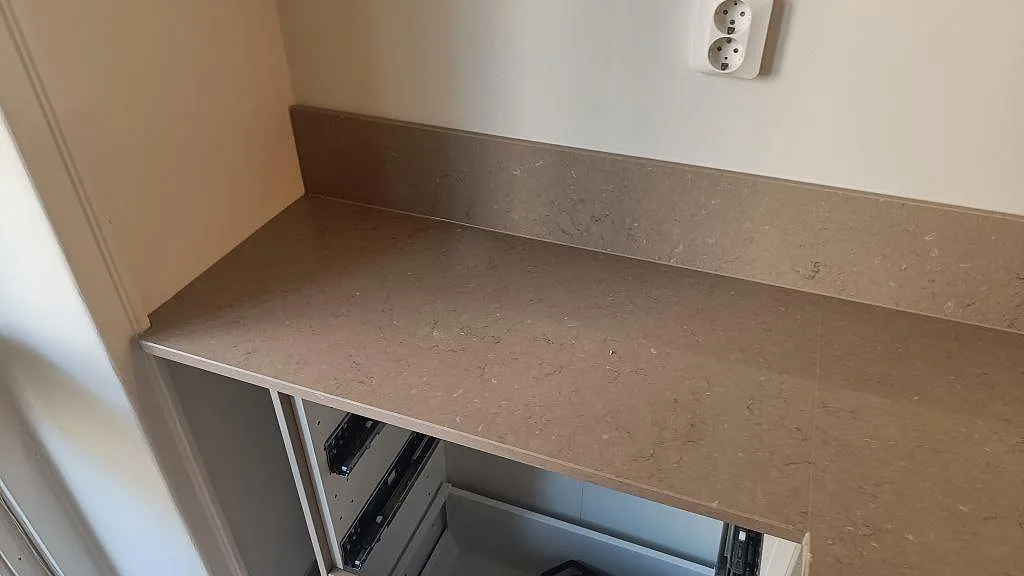 Sidovy av polerad köksbänkskiva i Silestone Coral Clay med 12 mm stänkkant och öppna stommar i ett kök i Malmö.