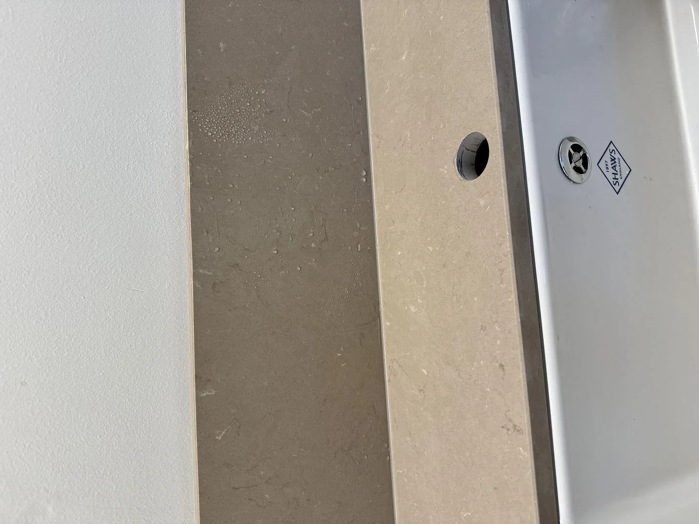 Detaljbild av polerad Silestone Coral Clay vid diskho och stänkskydd i kök i Malmö.