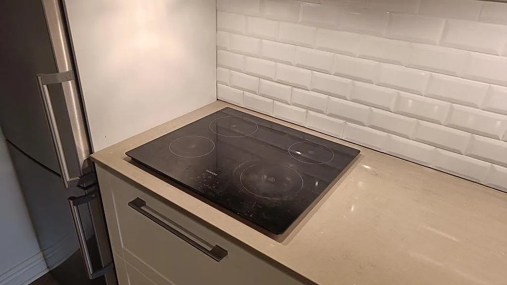Hällzon i polerad köksbänkskiva av Silestone Coral Clay, gråbeige kvartskomposit, i ett Malmö-kök.
