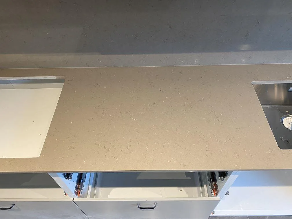 Polerad Silestone Coral Clay komposit mellan hällöppning och rostfri diskho, med matchande stänkvägg i kök i Malmö.