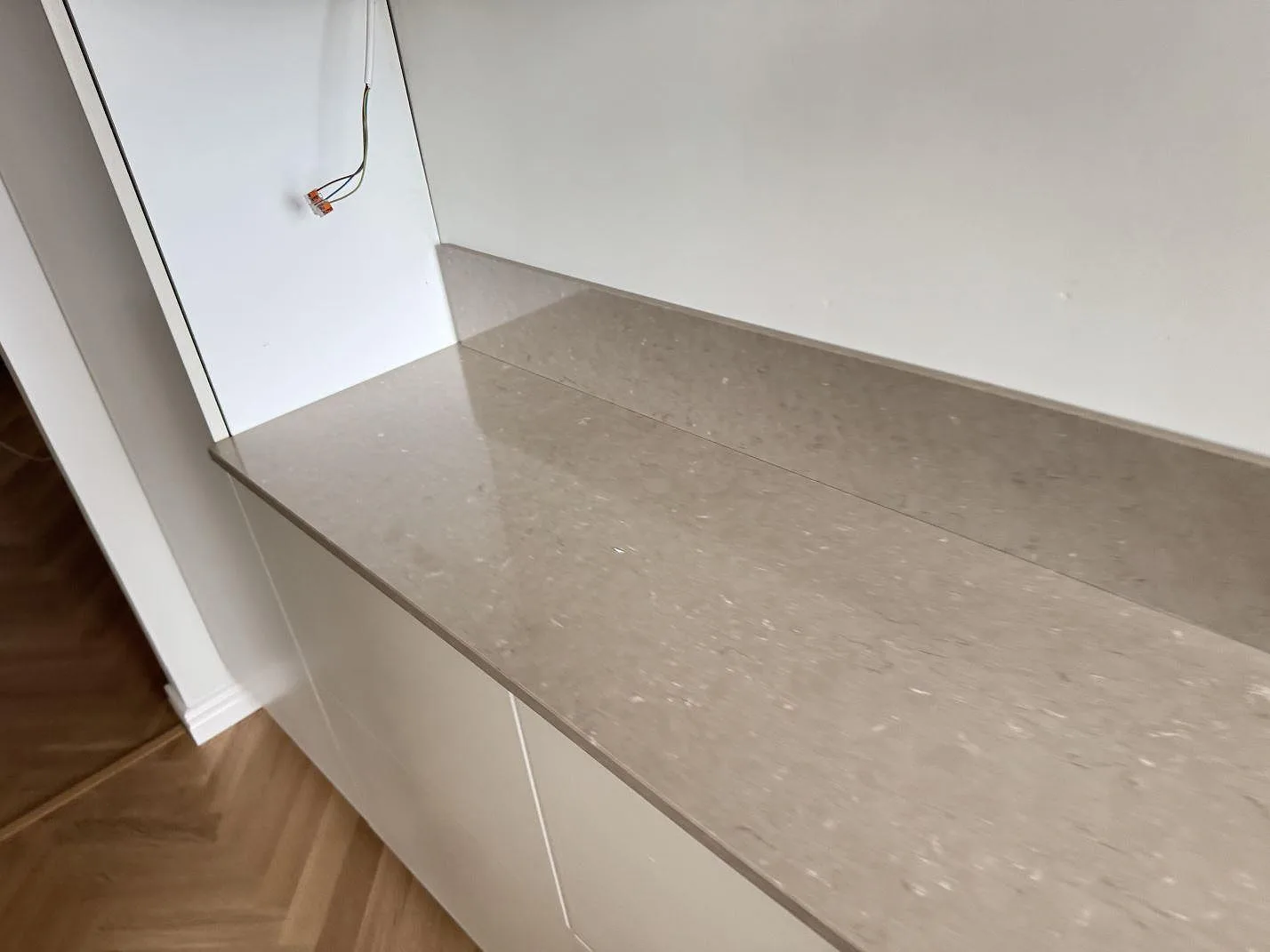 Rak köksbänkskiva i polerad Silestone Coral Clay med låg stänkkant och ljusa stommar i Malmö.