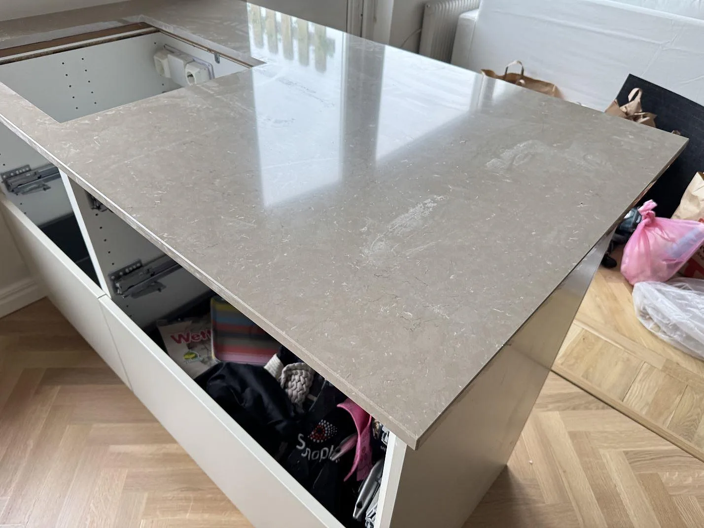 Bred köksbänkskiva i polerad Silestone Coral Clay med synlig ådring och diskhouskärning under montering i Malmö.