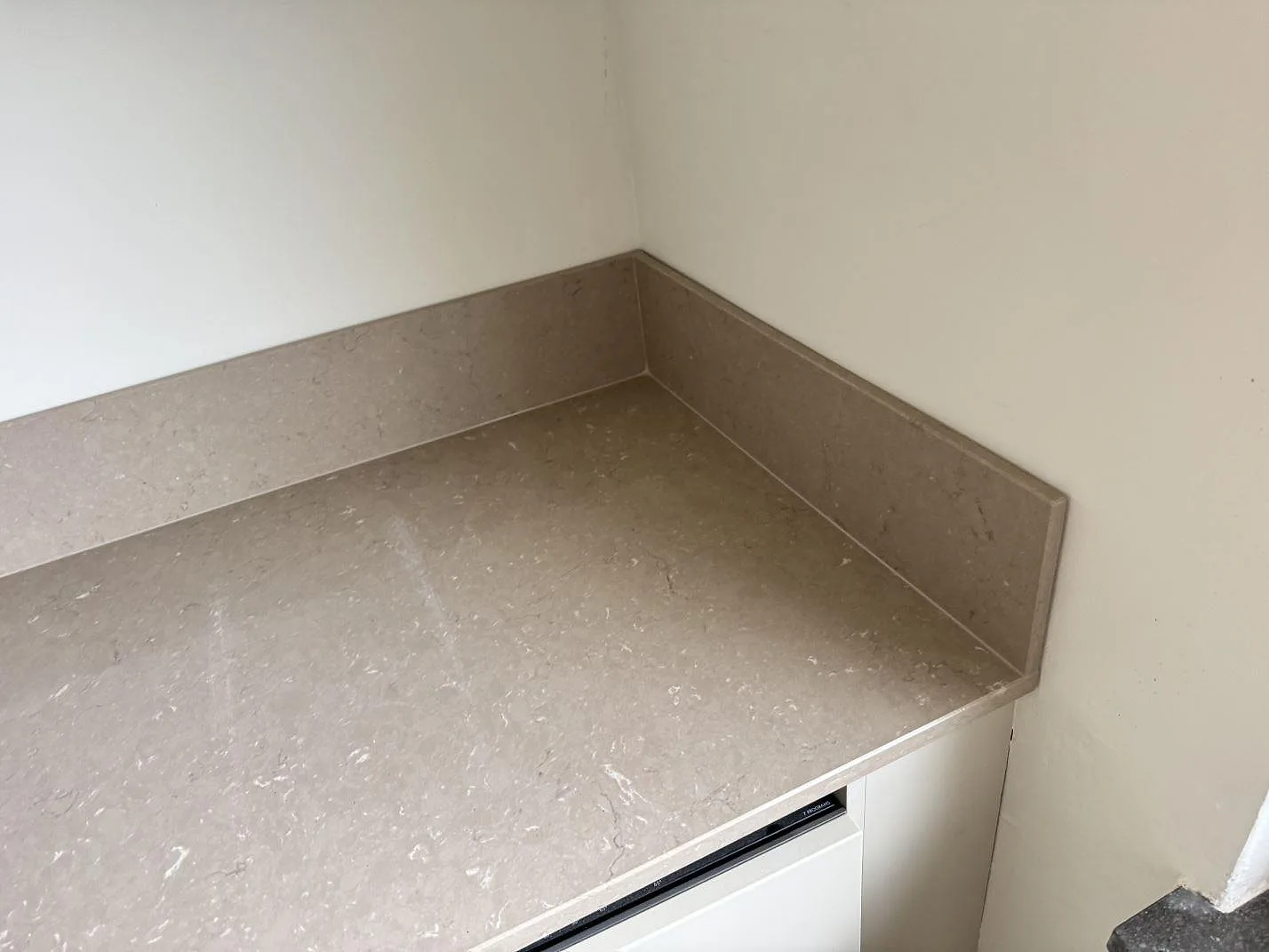 Hörn av köksbänkskiva i polerad Silestone Coral Clay med matchande stänkkant i Malmö.