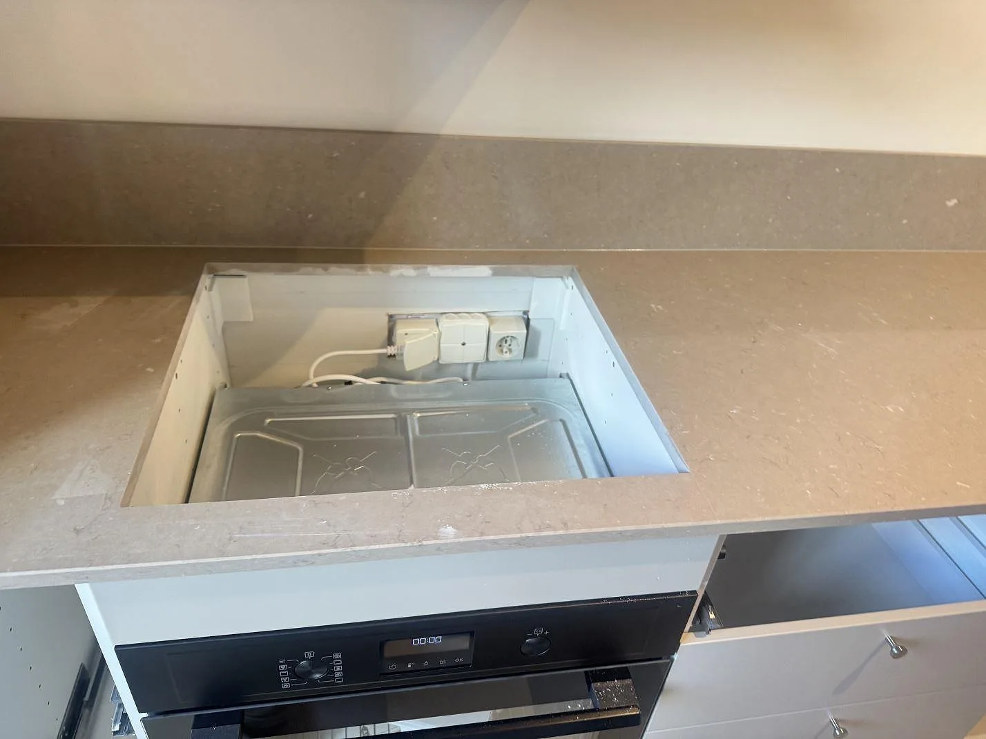 Topvy över hällurtag i polerad Silestone Coral Clay med matchande stänkskydd och öppna köksstommar i Malmö.