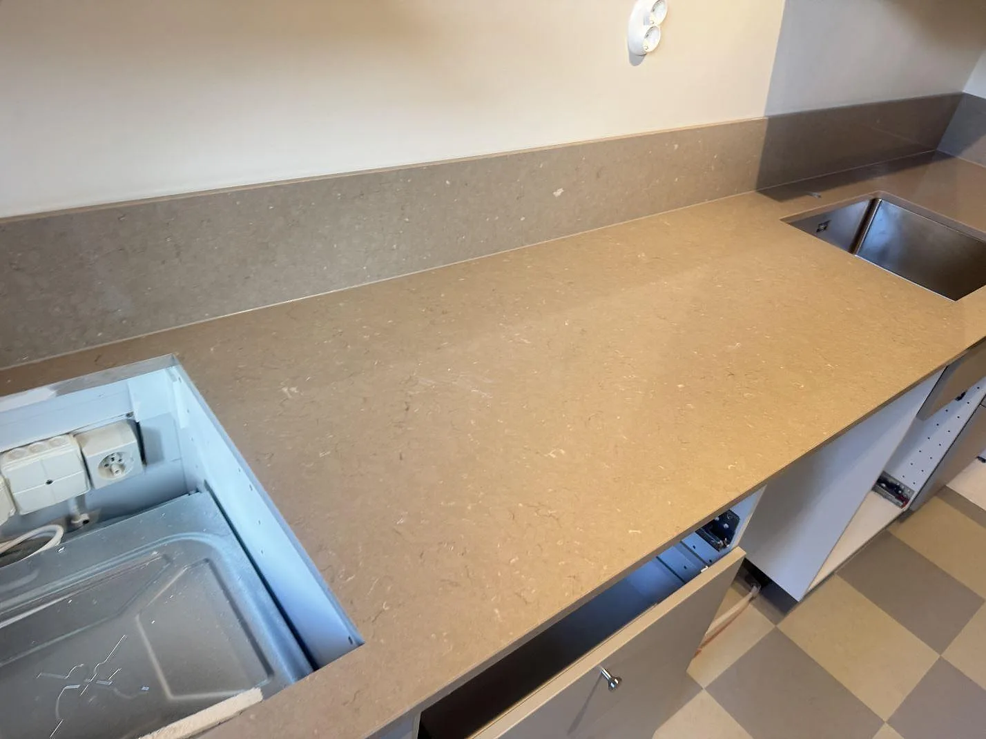 Köksbänkskiva i polerad Silestone Coral Clay med 12 mm stänkskydd, diskho och hällurtag i ett kök i Malmö.