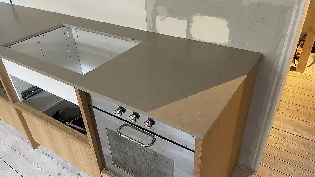 Närbild på 20 mm Silestone Coral Clay Mocka runt hällöppning och ugn i en köksmontering i Malmö.
