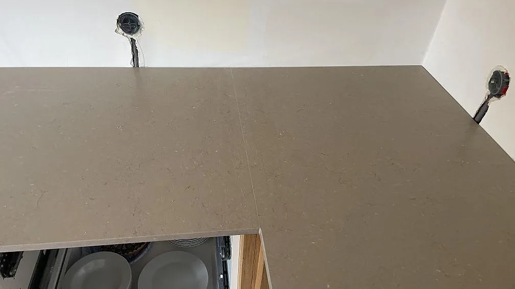 Skarv och arbetsyta i Silestone Coral Clay Mocka över ljusa trästommar under montering i Malmö.