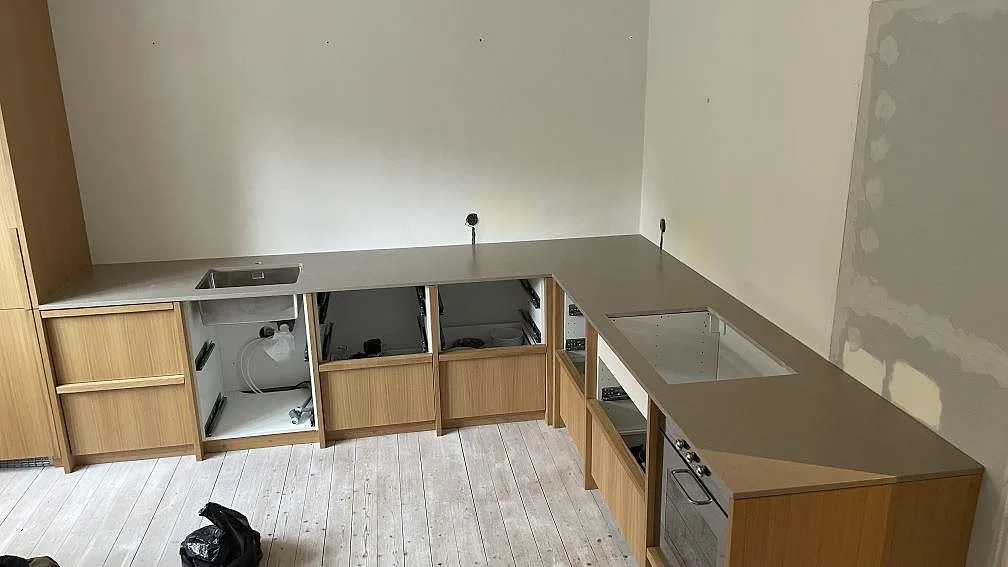 L-formad köksbänkskiva i Silestone Coral Clay Mocka med rostfri diskho och hällöppning i ett kök i Malmö.