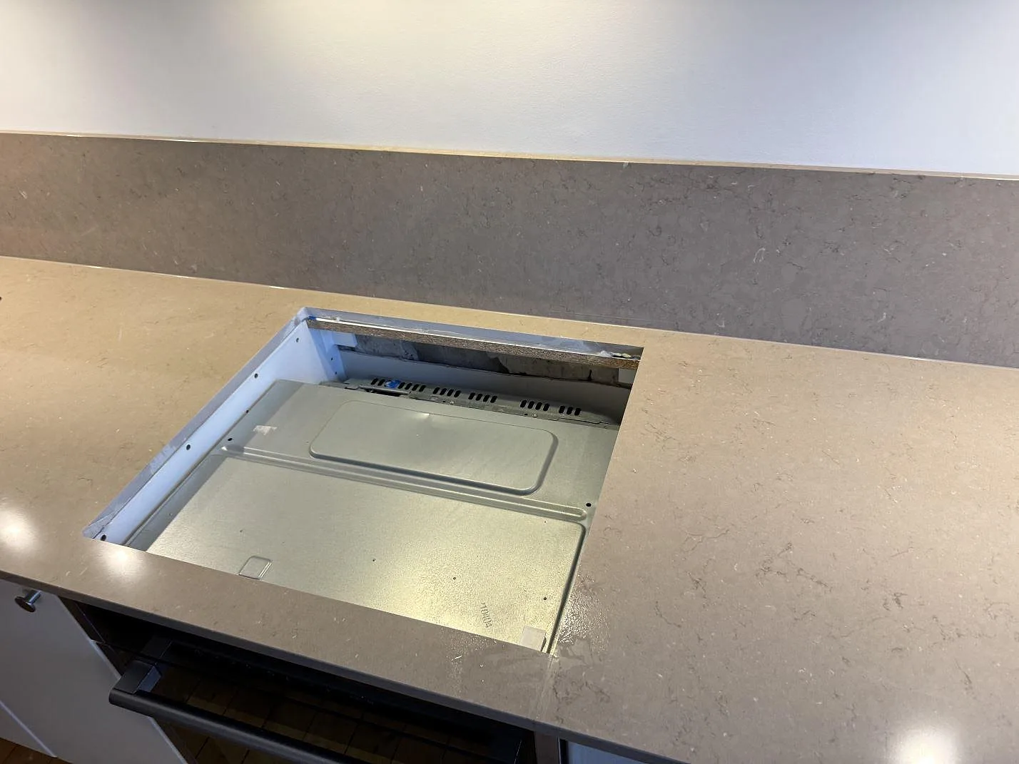 Urtagning för induktionshäll i polerad Silestone Coral Clay köksbänkskiva i Malmö, fotograferad under montering.