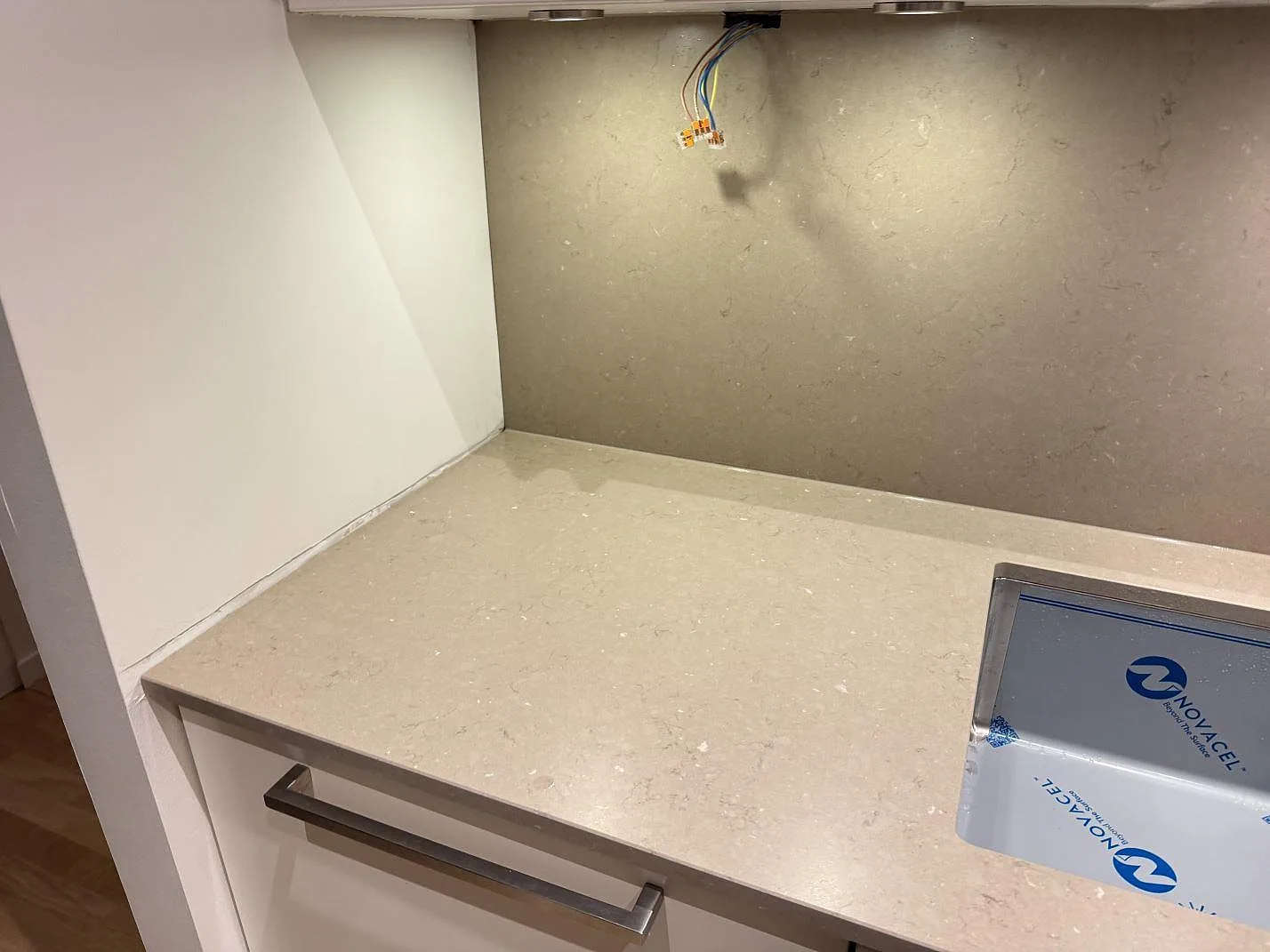 Köksbänkskiva i Silestone Coral Clay, matt Mocka-yta, med stänkskydd i samma sten och underlimmad rostfri diskho i ett kök under montering i Malmö.