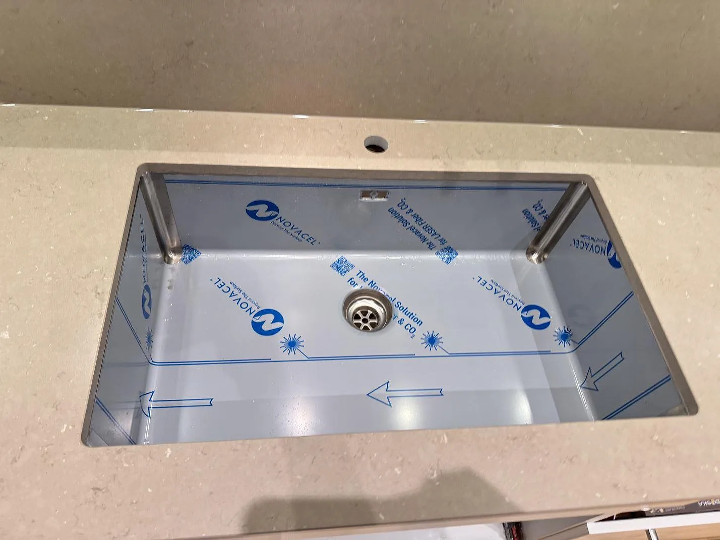 Ovanifrån på underlimmad rostfri diskho i beige Silestone Coral Clay köksbänkskiva med matt Mocka-yta i ett kök i Malmö.